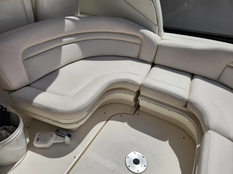Slide: The Image of 2003 Sea Ray 340 Sundancer interior seating with cream upholstery and cleaning supplies. - 9