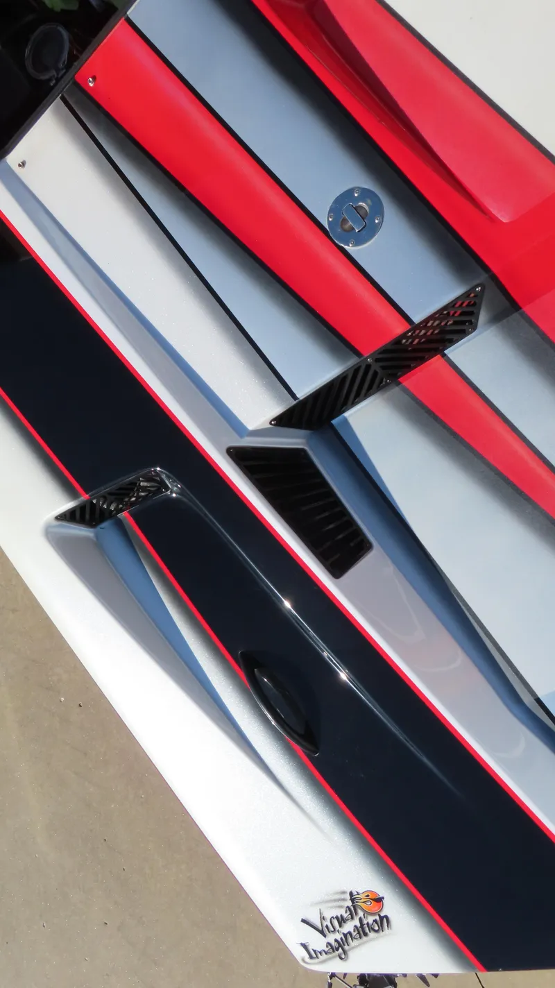 Slide: The Image of Close-up of a 2014 MTI 44 boat with sleek red and black design elements. - 11