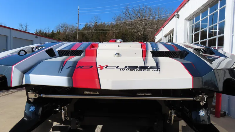 Slide: The Image of 2014 MTI 44 boat with red, white, and blue design, parked outside a building. - 18