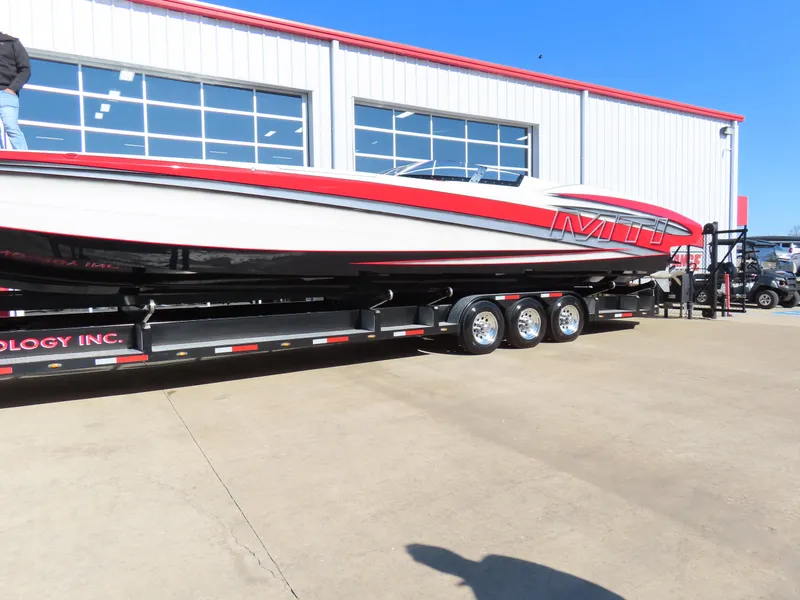 Slide: The Image of 2014 MTI 44 boat on trailer outside a garage. - 2