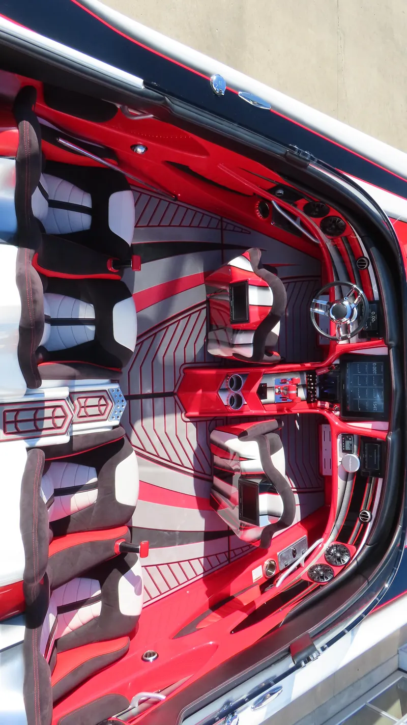 Slide: The Image of 2014 MTI 44 boat interior with red and black seating and modern dashboard. - 21