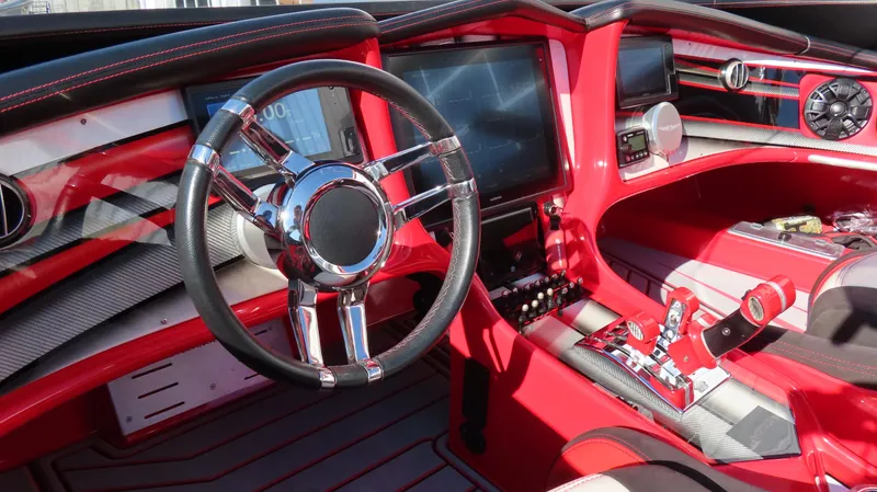 Slide: The Image of Red MTI 44 boat interior, 2014 model, featuring sleek steering wheel and modern dashboard. - 29