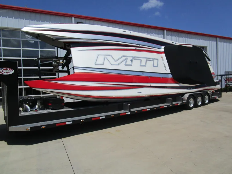 Slide: The Image of 2014 MTI 44 powerboat on trailer, featuring sleek red and white design. - 7
