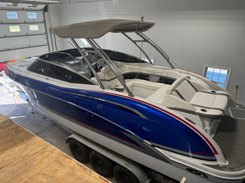 Slide: The Image of 2014 Formula 310 FX5 boat with blue and white design in a garage setting. - 17