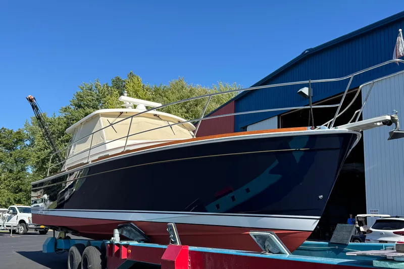 Slide: The Image of 2008 Sabre 38 Hardtop Express boat on trailer near blue and red building. - 14