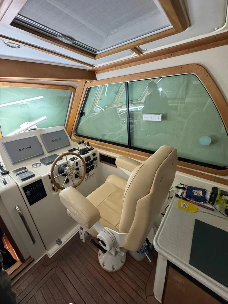 Slide: The Image of 2008 Sabre 38 Hardtop Express helm with beige captain's chair and navigation equipment. - 23