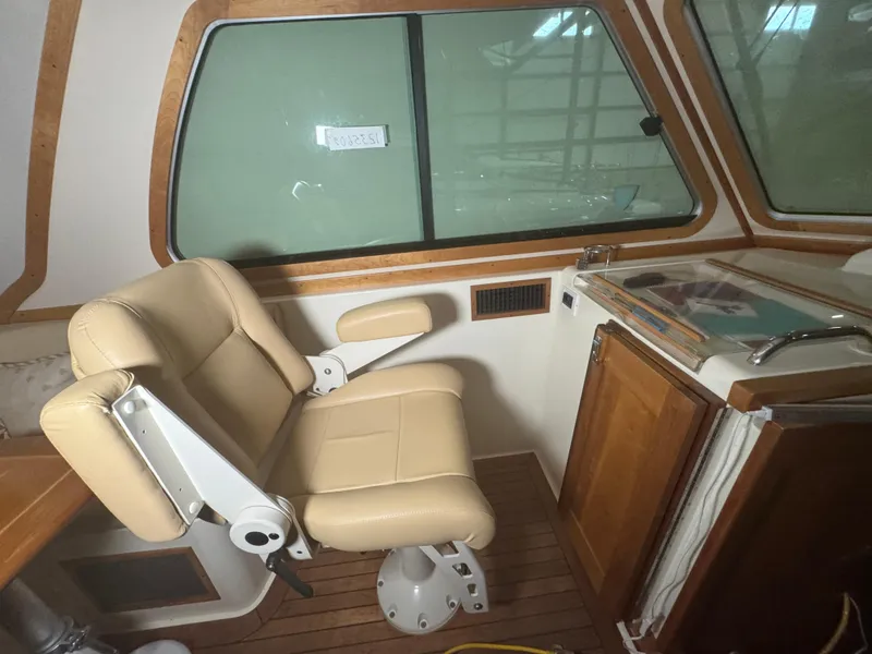 Slide: The Image of Interior of 2008 Sabre 38 Hardtop Express with beige captain's chair and wooden cabinetry. - 28