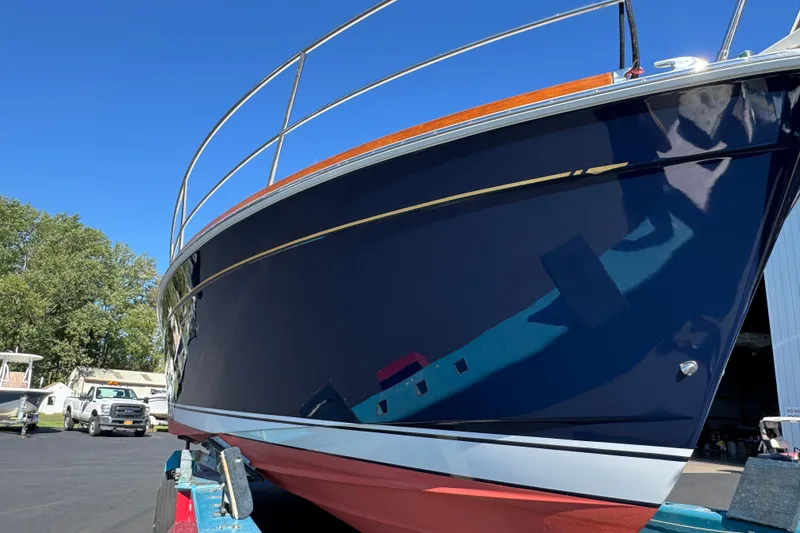 Slide: The Image of 2008 Sabre 38 Hardtop Express boat with sleek blue hull, docked outdoors. - 3