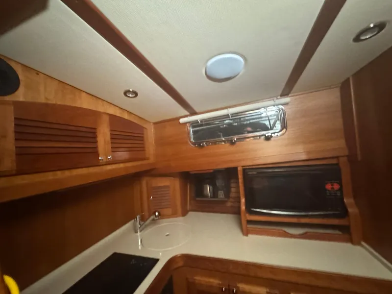 Slide: The Image of 2008 Sabre 38 Hardtop Express galley with wood cabinetry, sink, and microwave. - 34