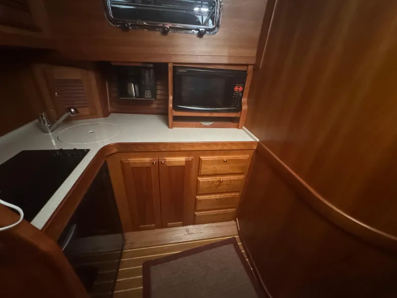 Slide: The Image of 2008 Sabre 38 Hardtop Express galley with wood cabinetry, microwave, and sink. - 35