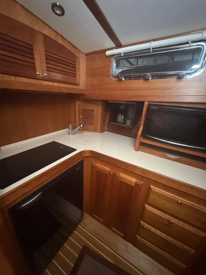 Slide: The Image of 2008 Sabre 38 Hardtop Express galley with wood cabinetry, sink, stove, and microwave. - 36