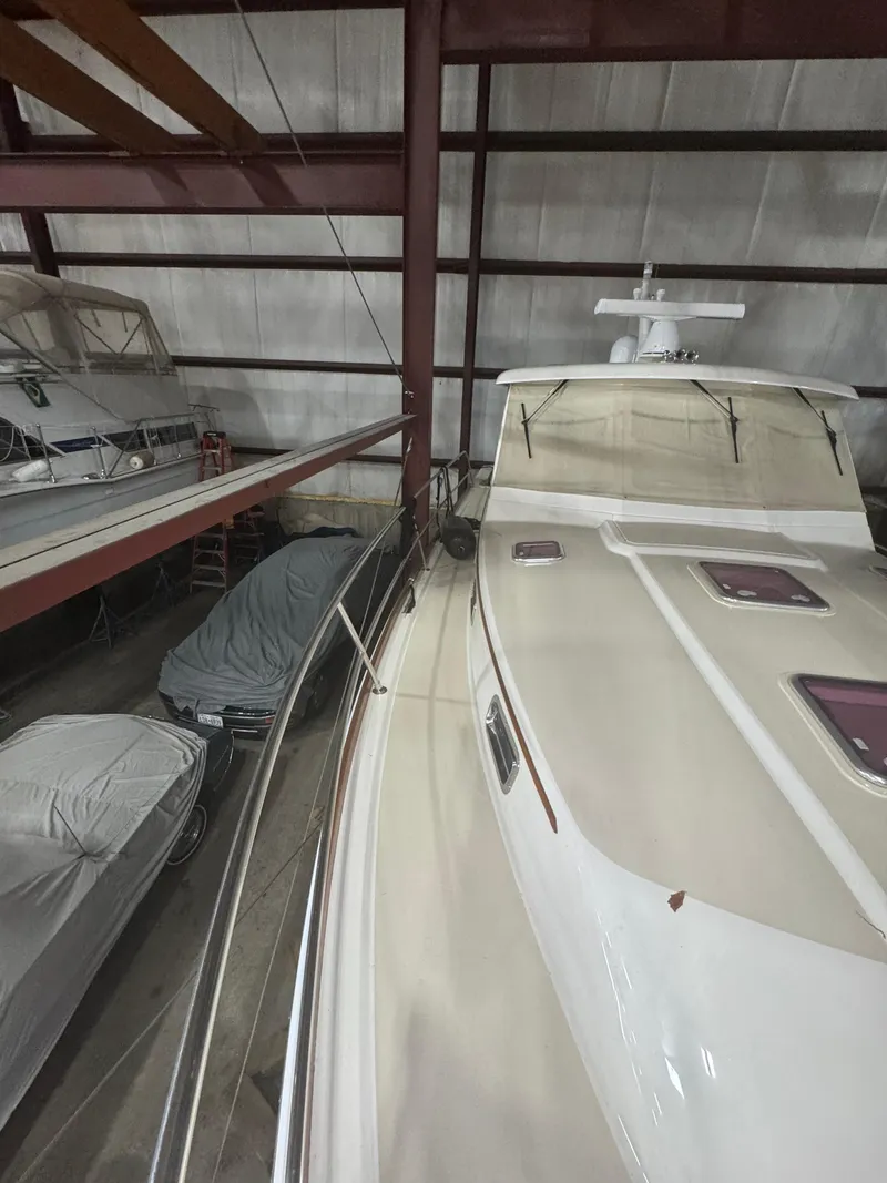 Slide: The Image of 2008 Sabre 38 Hardtop Express yacht stored indoors, alongside covered vehicles. - 55