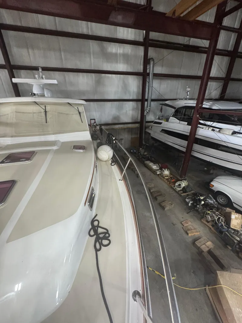Slide: The Image of 2008 Sabre 38 Hardtop Express yacht stored indoors, alongside other boats and equipment. - 56