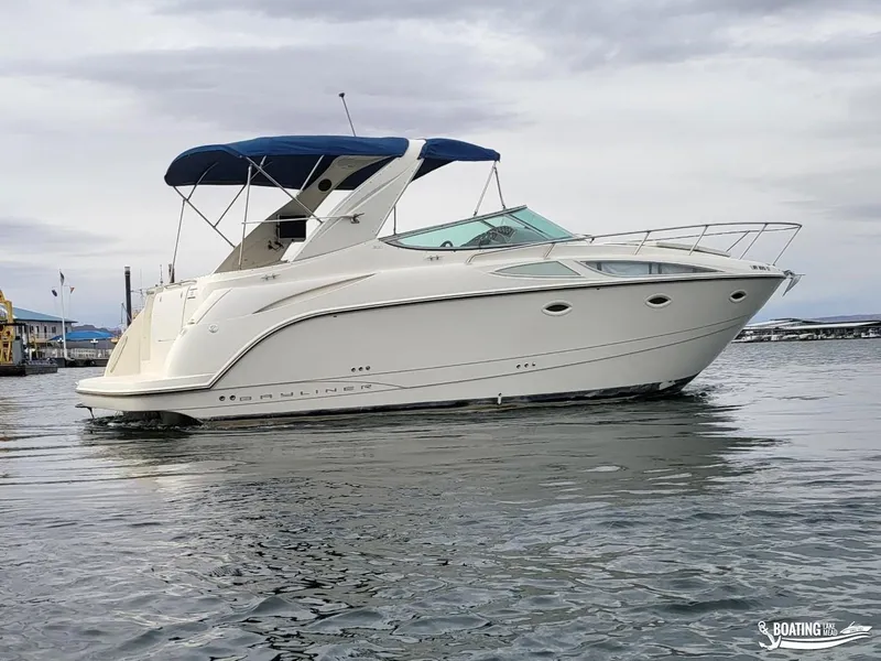 Slide: The Image of 2008 Bayliner 300SB boat with blue canopy on calm water. - 11