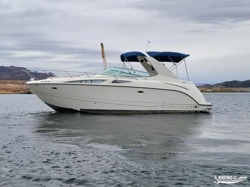 Slide: The Image of 2008 Bayliner 300SB boat on calm water with blue canopy. - 12