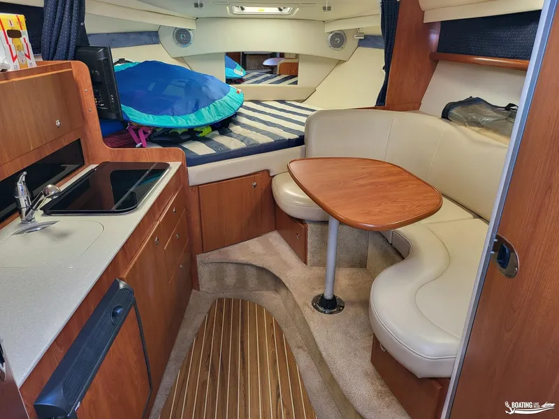 Slide: The Image of Interior of 2008 Bayliner 300SB boat with kitchenette and seating area. - 16