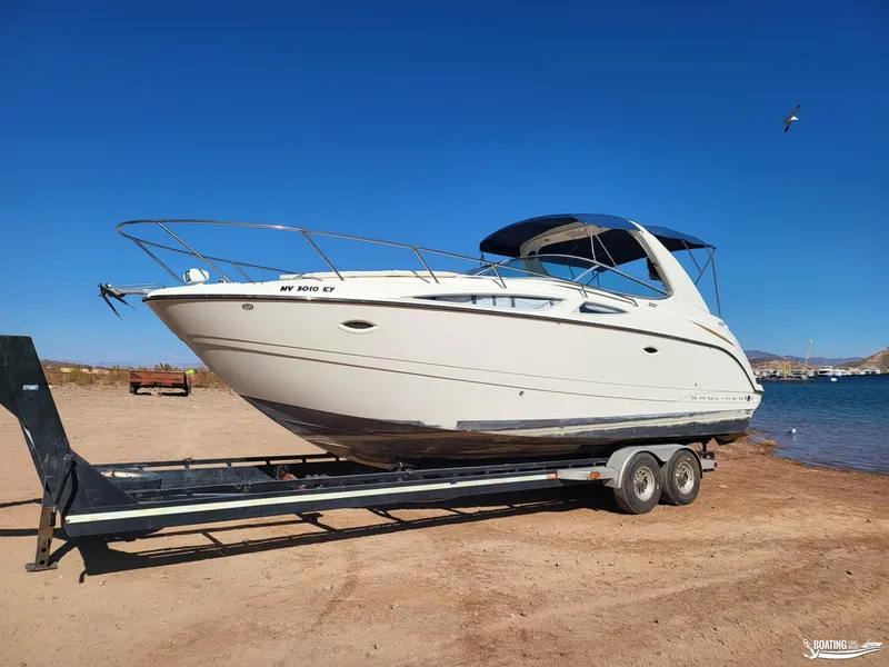 Slide: The Image of 2008 Bayliner 300SB boat on trailer by the beach under clear blue sky. - 17
