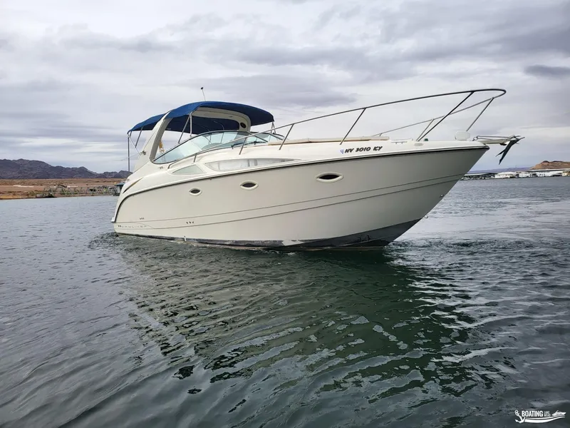 Slide: The Image of 2008 Bayliner 300SB boat cruising on a calm lake under cloudy skies. - 2