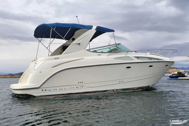 Slide: The Image of 2008 Bayliner 300SB boat with blue canopy on calm water. - 4