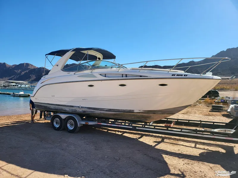 Slide: The Image of 2008 Bayliner 300SB boat on trailer by lake, clear sky, mountainous background. - 7
