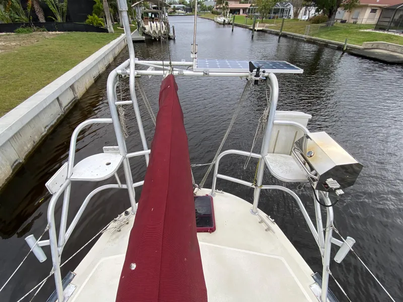 Slide: The Image of 1986 Bruce Roberts 43 Ketch with red canopy, docked by a canal. - 15
