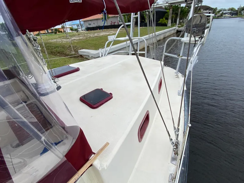 Slide: The Image of 1986 Bruce Roberts 43 Ketch sailboat deck with maroon accents, docked by a canal. - 16