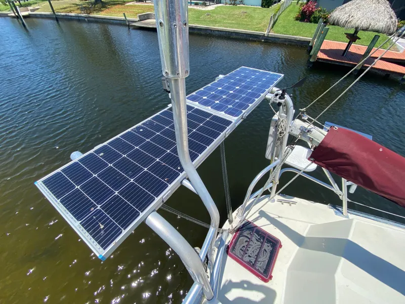 Slide: The Image of 1986 Bruce Roberts 43 Ketch sailboat docked, featuring maroon sail cover and deck view. - 17