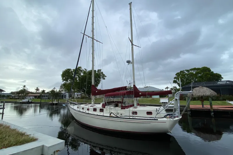 Slide: The Image of 1986 Bruce Roberts 43 Ketch sailboat docked in a serene marina setting. - 2