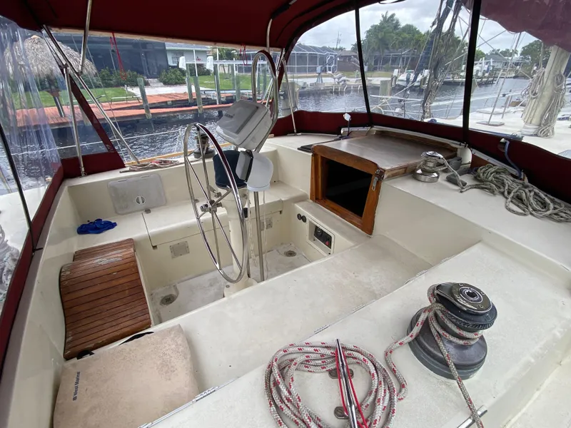 Slide: The Image of Bruce Roberts 43 Ketch, 1986, docked in a canal with palm trees and houses. - 21