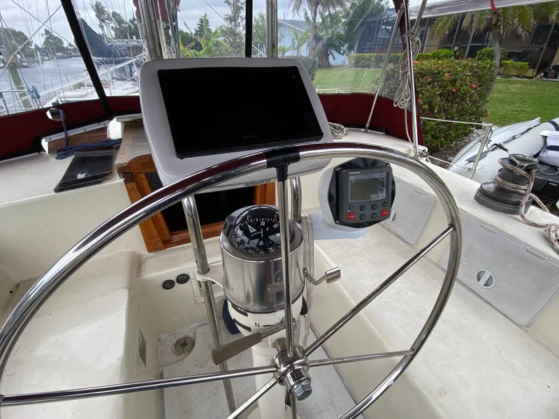 Slide: The Image of 1986 Bruce Roberts 43 Ketch sailboat docked, featuring a clean deck and maroon canopy. - 22