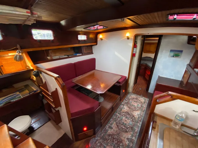 Slide: The Image of 1986 Bruce Roberts 43 Ketch sailboat mast against cloudy sky and tree backdrop. - 24