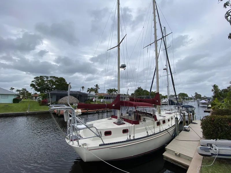 Slide: The Image of 1986 Bruce Roberts 43 Ketch docked in a serene marina setting. - 3