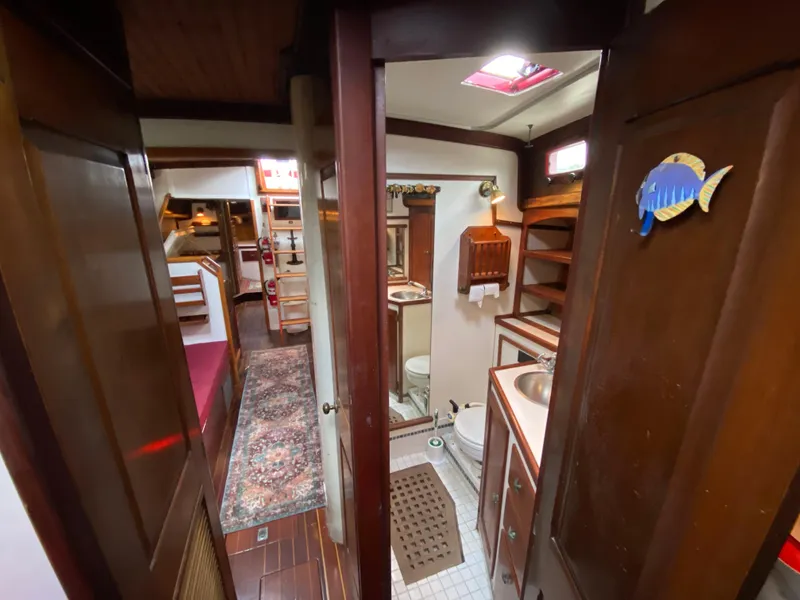 Slide: The Image of Interior of a 1986 Bruce Roberts 43 Ketch, featuring a cozy dining and kitchen area. - 32