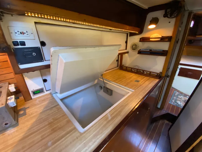 Slide: The Image of Interior of 1986 Bruce Roberts 43 Ketch, featuring wood paneling and red cushioned seating. - 35