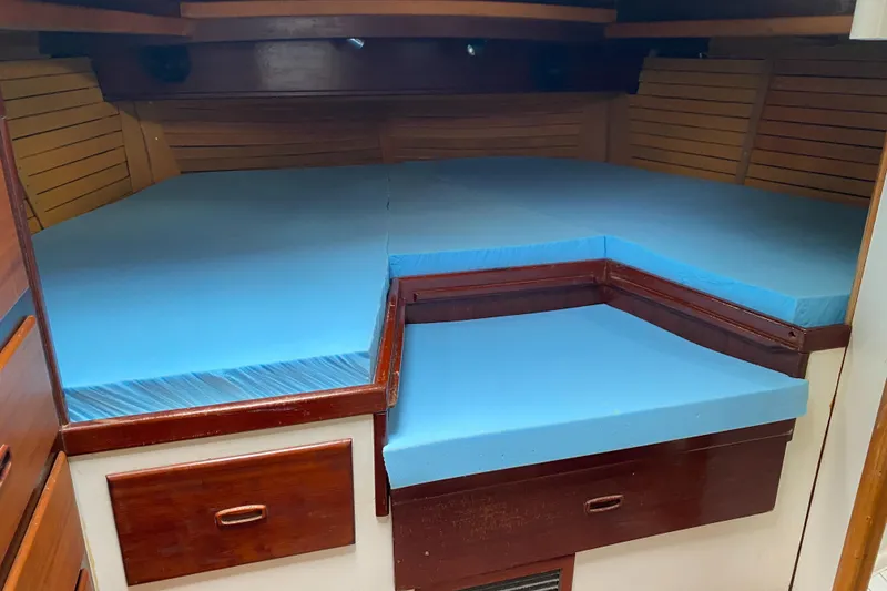 Slide: The Image of Cozy cabin interior of 1986 Bruce Roberts 43 Ketch with wooden shelves and bedding. - 38