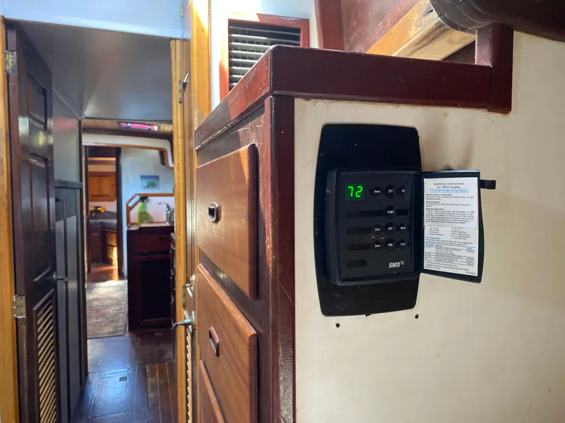 Slide: The Image of Interior cabin of 1986 Bruce Roberts 43 Ketch, featuring wooden paneling and storage shelves. - 39