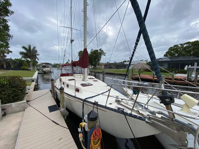 Slide: The Image of 1986 Bruce Roberts 43 Ketch docked by a scenic canal under cloudy skies. - 4