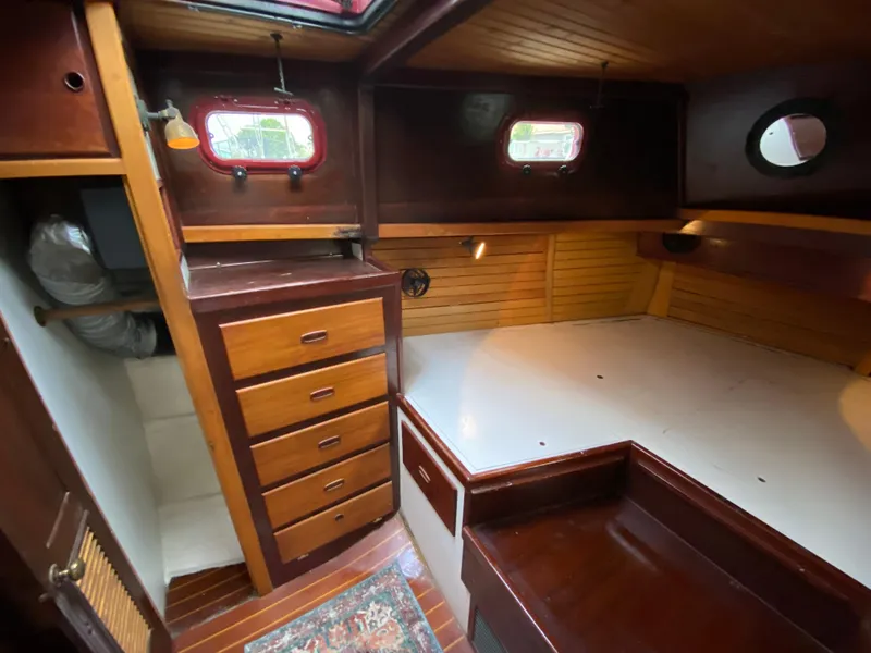 Slide: The Image of Interior of 1986 Bruce Roberts 43 Ketch, featuring wooden cabinetry and cozy sleeping area. - 50