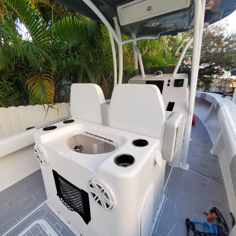 Slide: The Image of 1976 Formula 233 boat interior with seating and console, surrounded by lush greenery. - 14