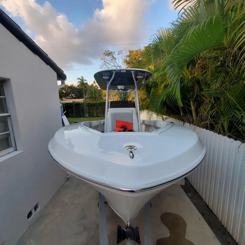 Slide: The Image of 1976 Formula 233 boat parked beside a house, surrounded by lush greenery. - 15