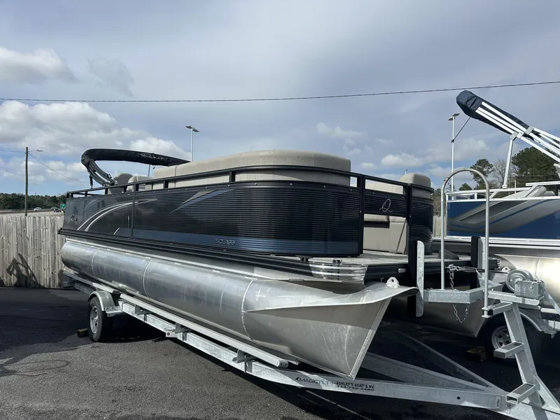 Slide: The Image of 2023 Qwest Pontoons XRE Cruise 22 on trailer, parked outdoors under cloudy sky. - 1
