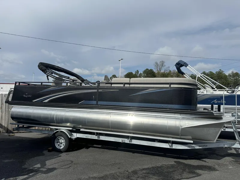 Slide: The Image of 2023 Qwest Pontoons XRE Cruise 22 on trailer, sleek design, outdoor display. - 7