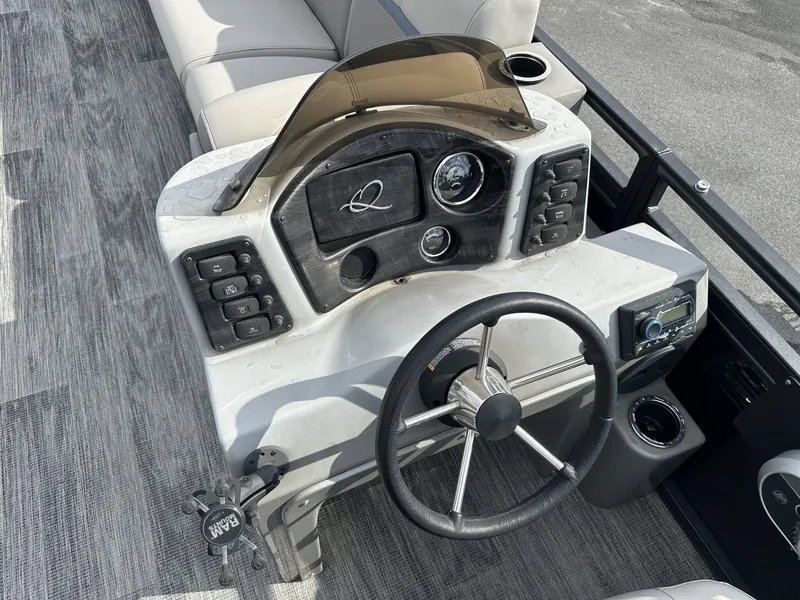 Slide: The Image of 2023 Qwest Pontoons XRE Cruise 22 dashboard with steering wheel and controls. - 9