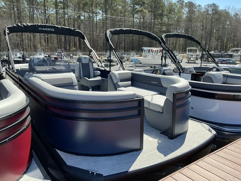 Slide: The Image of 2025 Viaggio Lago V 22U pontoon boat docked, featuring spacious seating and sleek design. - 2