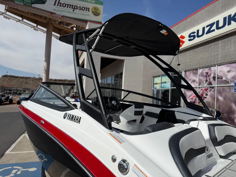 Slide: The Image of 2025 Yamaha Boats AR195 with sleek design, parked near Suzuki dealership. - 18