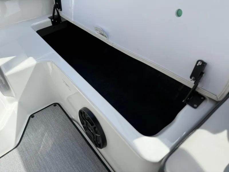 Slide: The Image of 2025 Yamaha Boats AR195 storage compartment with open lid and speaker. - 28