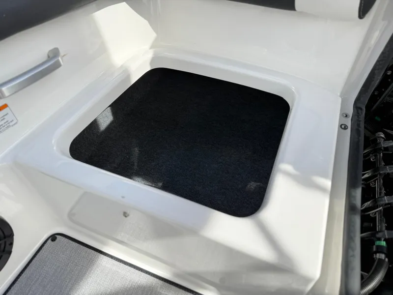 Slide: The Image of 2025 Yamaha Boats AR195 interior storage compartment with black mat. - 30