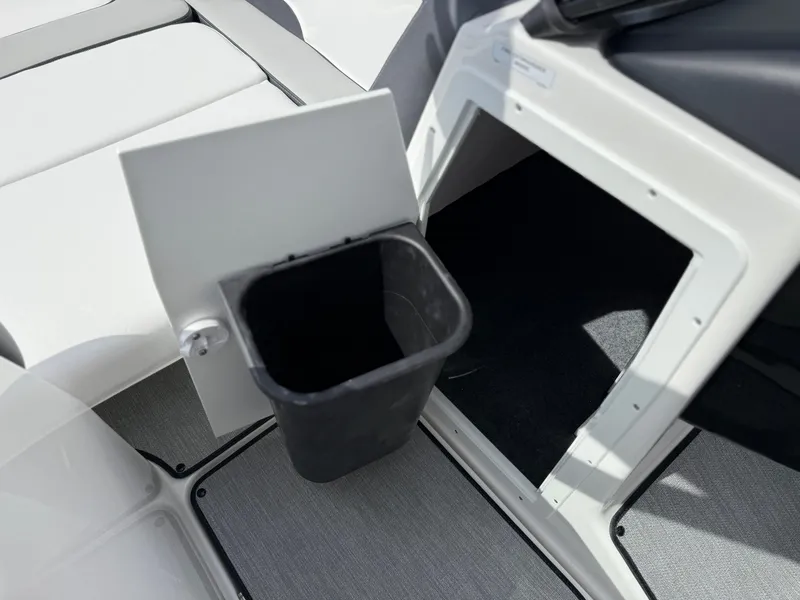 Slide: The Image of Interior of 2025 Yamaha AR195 boat showing storage compartment with trash bin. - 45