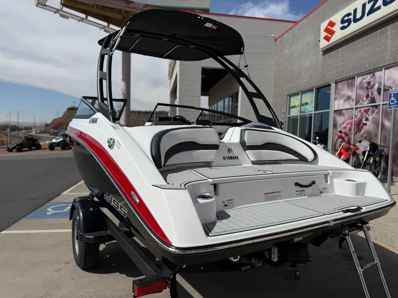 Slide: The Image of 2025 Yamaha Boats AR195, sleek design, parked outside Suzuki dealership. - 5