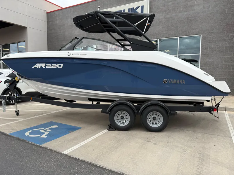 Slide: The Image of 2025 Yamaha Boats AR220 on trailer, parked in a lot near a building. - 12